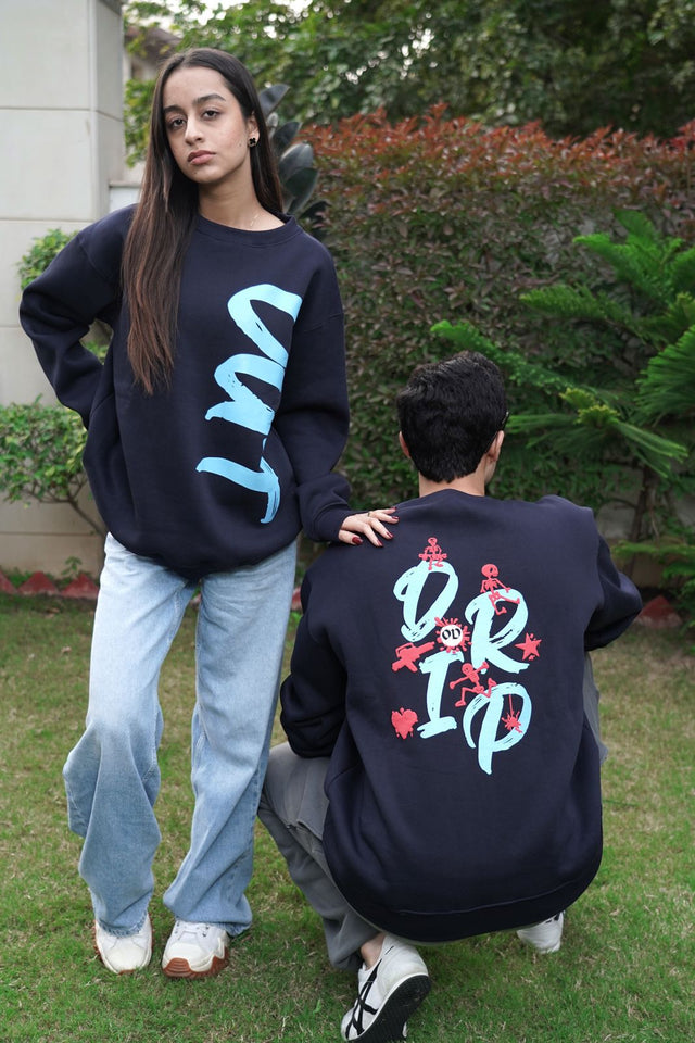 Couple styled in blue Skulls Edition sweatshirts by Outdrip, reflecting a unisex streetwear vibe.
