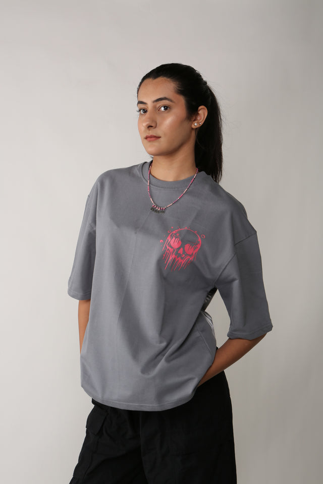 Female model styled in SKULLS IN THE GRAVE T-shirt – streetwear-inspired puff and screen print on grey oversized tee