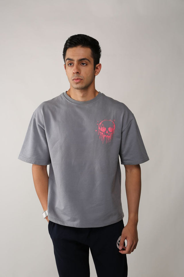 Male model in SKULLS IN THE GRAVE T-shirt – oversized grey t-shirt with skull-themed puff and screen print design