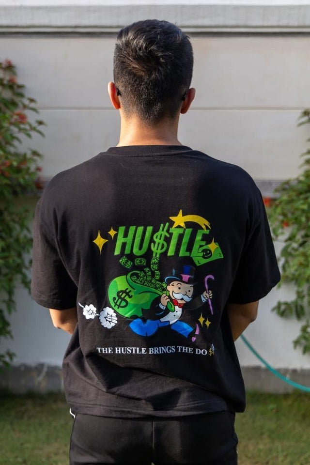 Male model wearing Outdrip’s Hustle Tee in black, styled for a casual streetwear look.
