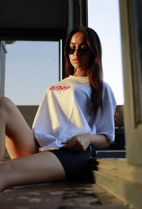 Female model in Outdrip’s white Love T-shirt, combining a clean look with impactful messaging.

